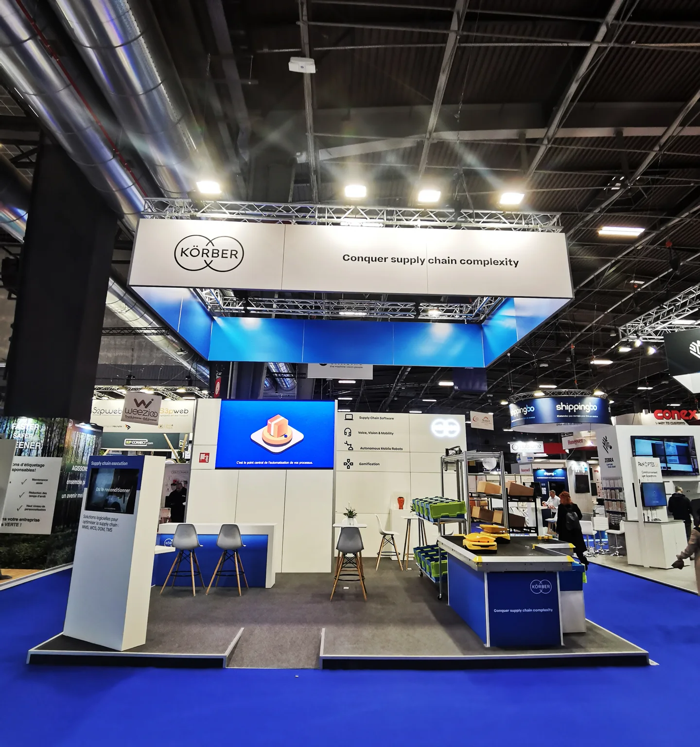Stand sur-mesure Körber Paris supply chain plafond bleu rétroéclairé